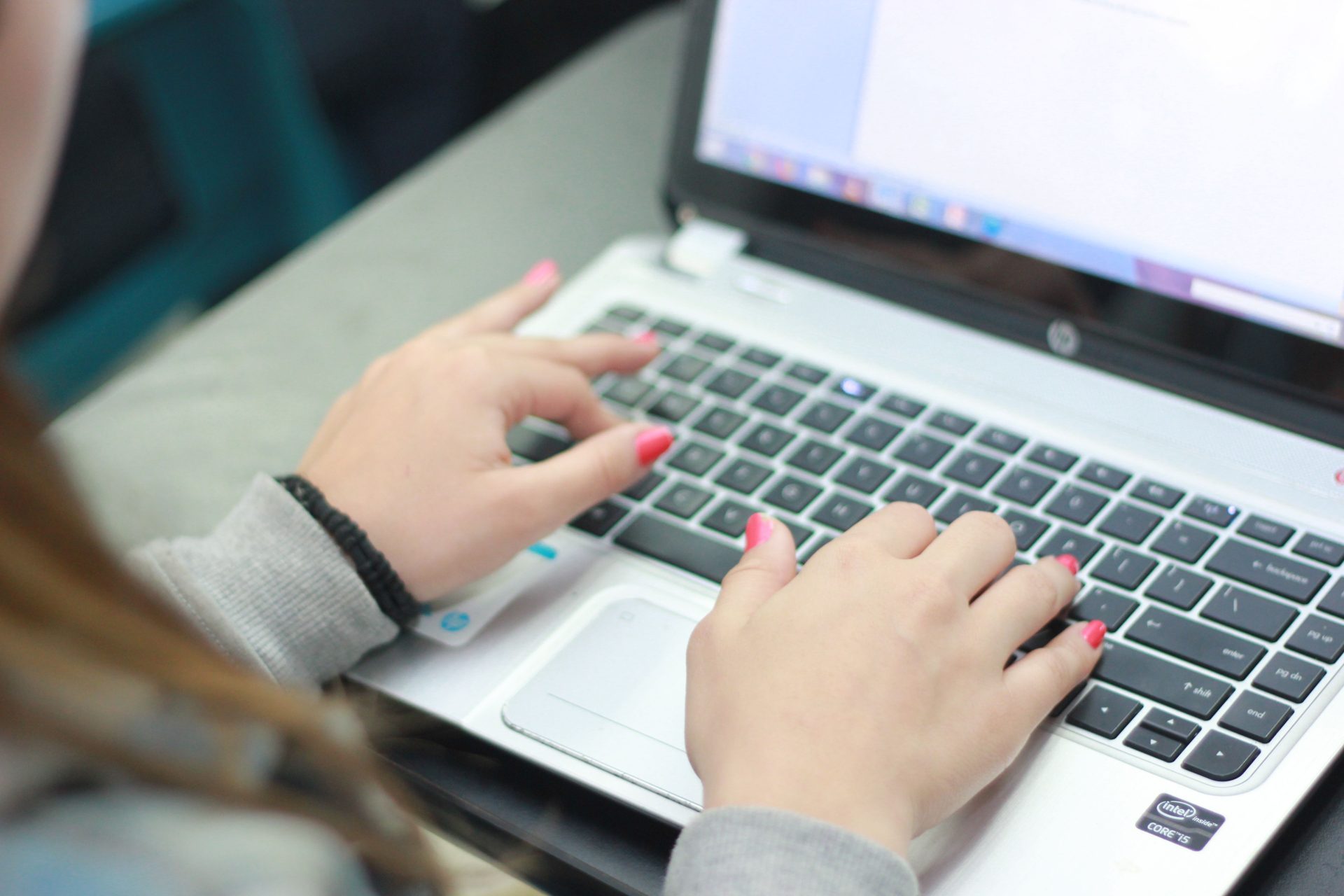 A professional typing on a laptop, using an AI receptionist to handle inquiries and boost lead conversions.